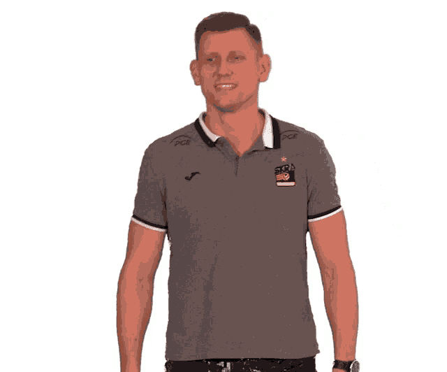 a man giving two thumbs up wearing a gray polo shirt with a logo on it