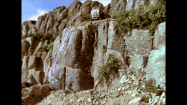 a truck is driving down the side of a rocky cliff