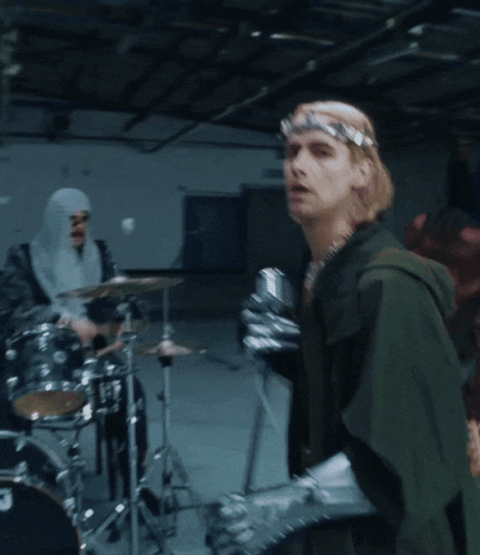 a man in armor is standing in front of a drum set that says dw on it