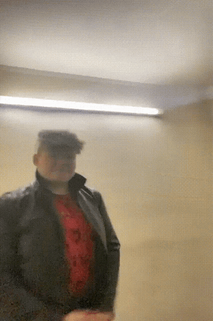 a blurry picture of a man wearing a hat and a jacket