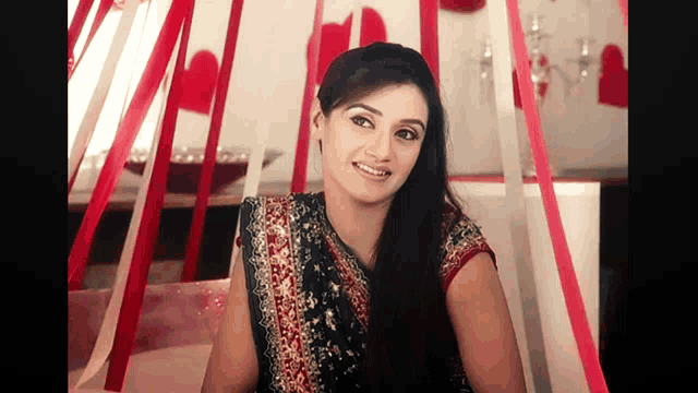 a woman in a black and gold dress is smiling