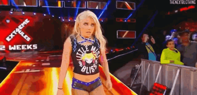 a woman in a wrestling outfit is walking down a ramp on a stage .