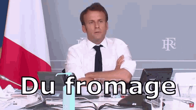 a man sitting at a desk with his arms crossed and the words du fromage written on the bottom