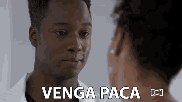 a man in a lab coat is looking at a woman and the words venga paca are visible