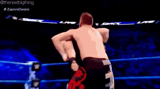 a wrestling match between zayn vs owens is being shown on a television screen