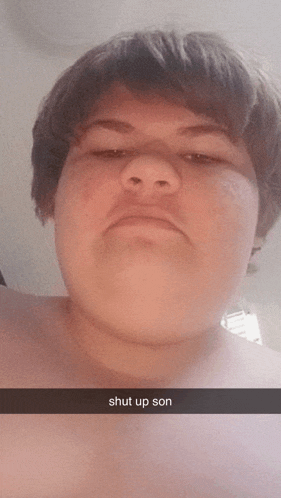 a young man taking a selfie with the words shut up son below him