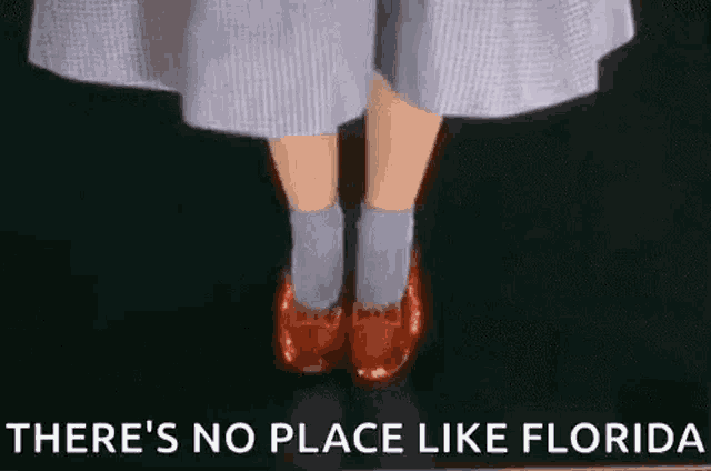 a woman wearing red shoes and socks is standing on a black floor .
