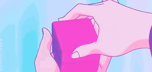 a person holding a pink box with a heart shaped ring inside