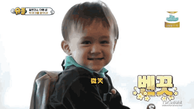 a little boy is smiling in front of a screen that says ' tsbs ' on it