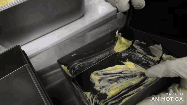 a person is spreading butter on a pan that says made in animatica on the bottom