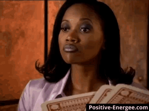 a woman holding a bunch of money in front of a positive-energiee.com banner