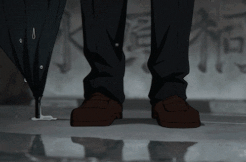 a person standing next to an umbrella with a reflection of their feet in the water