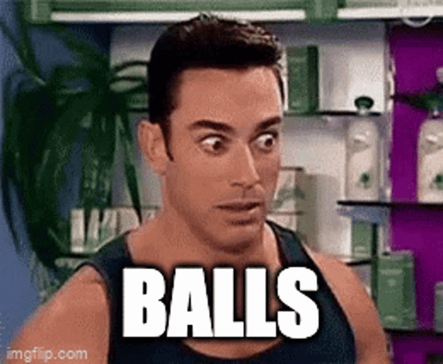 a man in a tank top is standing in front of a shelf that says balls .