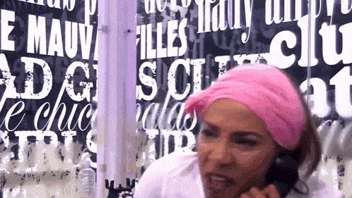 a woman wearing a pink headband stands in front of a wall that says " filles "