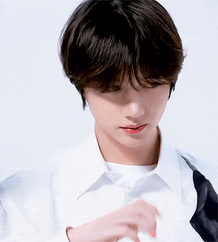 a close up of a young man 's face with a white shirt on