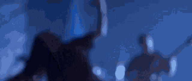 a blurry picture of a man singing into a microphone in a dark room
