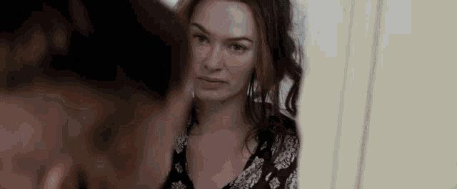 a woman is looking at herself in a mirror .