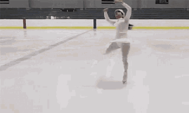 a woman is ice skating on a rink .