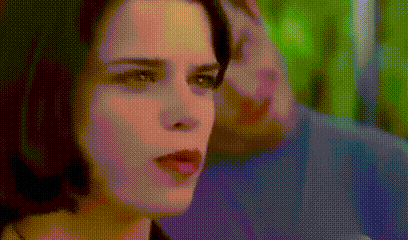 a close up of a woman 's face with a blurry background and a man in the background .