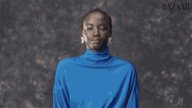 a woman wearing a blue turtleneck with anok yai on the front