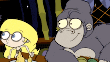 a girl and a gorilla are sitting at a table with a plate of food