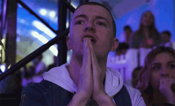 a man praying with his hands folded in front of a crowd