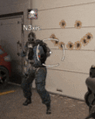 a man in a gas mask is standing in front of a garage door that has bullet holes in it