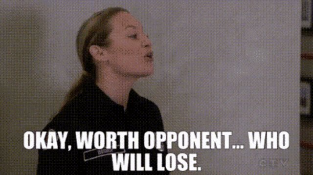a woman is standing in front of a wall and saying okay , worth opponent who will lose .