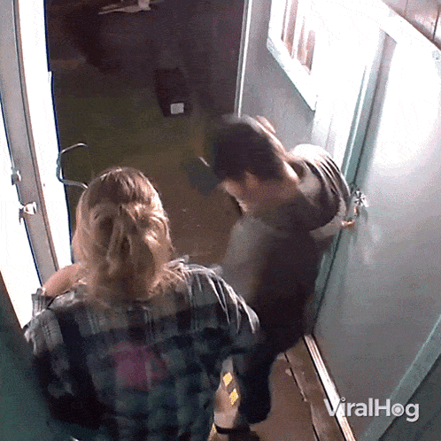 a man and a woman standing in a hallway with viralhog written on the bottom right