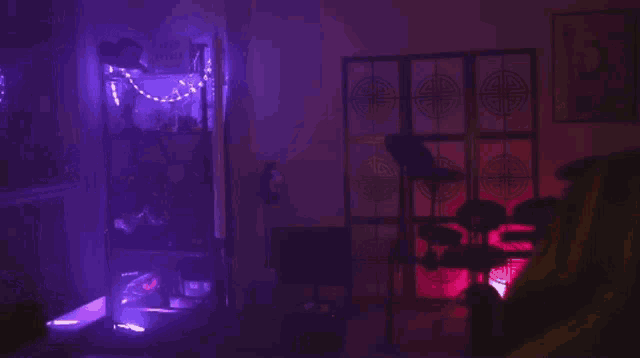 a person wearing a yellow hoodie is standing in a room with purple lights
