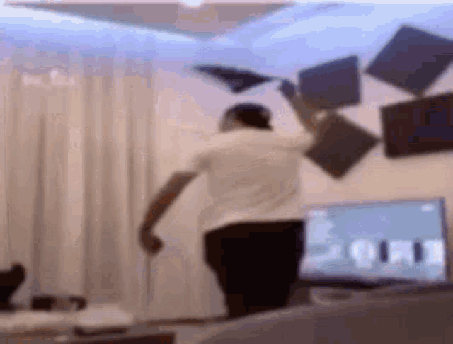 a blurry picture of a man standing in front of a computer screen .