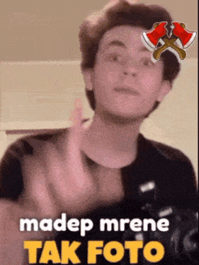 a young man is giving the middle finger with the words madep mrene tak foto below him .