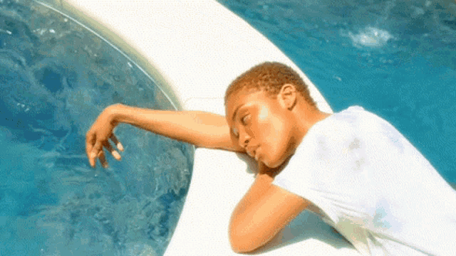 a woman laying on the edge of a swimming pool