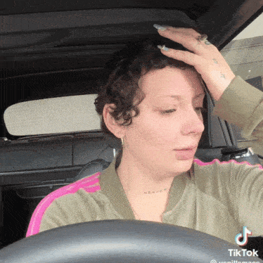 a woman in a car has a tattoo on her neck that says " heaven "