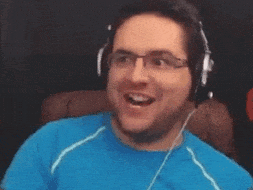 a man in a blue shirt is holding a gun in his hand .