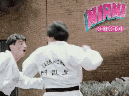 two taekwondo fighters are fighting in front of a miami correction sign