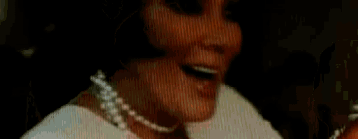 a close up of a woman 's face with a pearl necklace on .