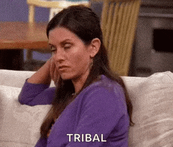a woman in a purple sweater is sitting on a couch with her eyes closed and her hand on her face .