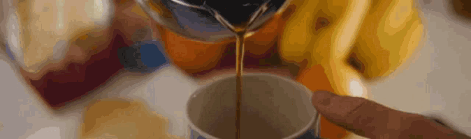 a cup of coffee is being poured into a cup