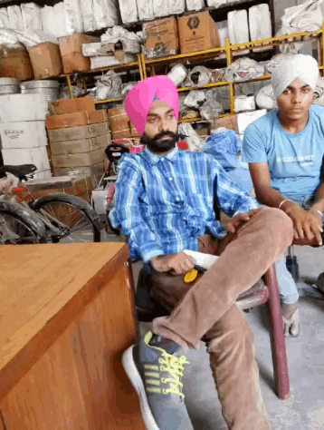 a man wearing a turban sits on a bench in a warehouse