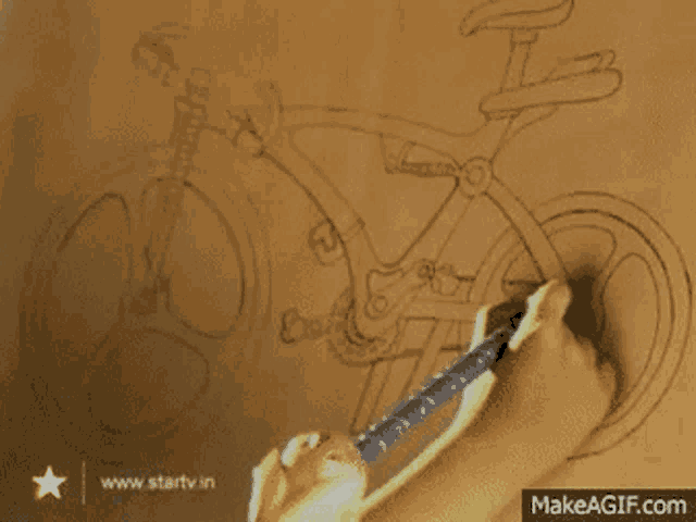 a person is drawing a bicycle on a piece of paper with makeagif.com in the corner