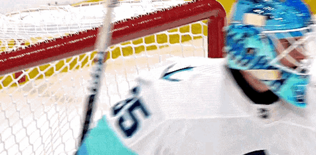 a hockey goalie wearing a white jersey with the number 56 on it