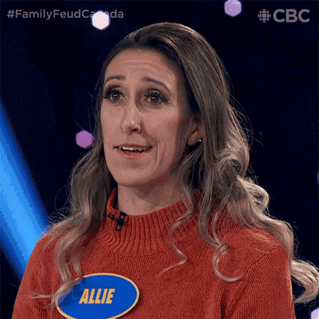 a woman in an orange sweater has a name tag that says allie