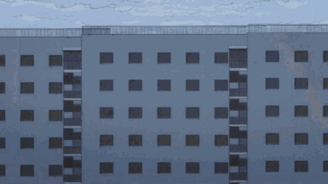 a girl in a yellow jacket is standing on a balcony in front of a door