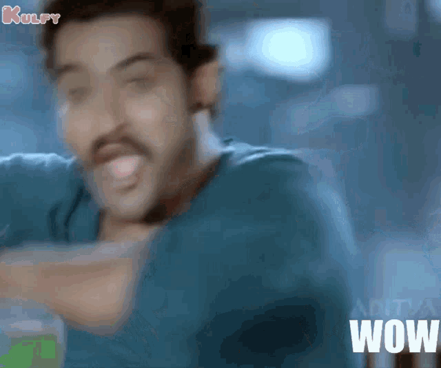 a man with a mustache is making a funny face and the word wow is visible in the corner