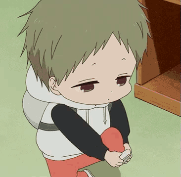 a little boy with a backpack is sitting on the floor with his legs crossed