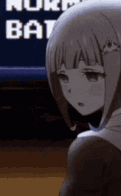 a girl is sitting in front of a tv that says nuke bat on it
