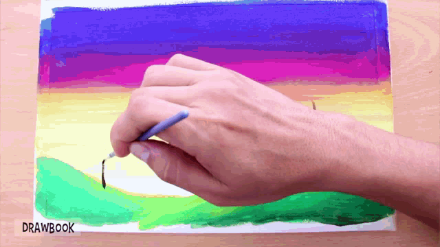 a person is drawing a rainbow colored landscape with drawbook written on the bottom right corner