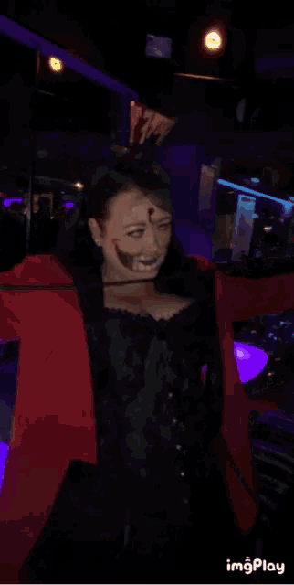 a woman with a clown face painted on her face is wearing a top hat with blood on it