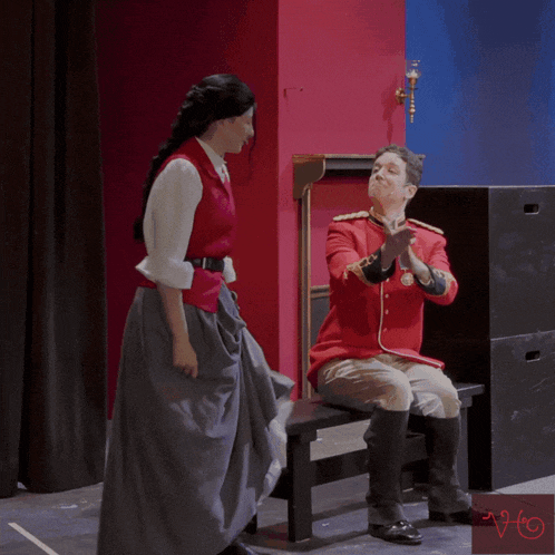 a man in a red uniform sits on a bench with a woman standing next to him and the words congratulations written above them